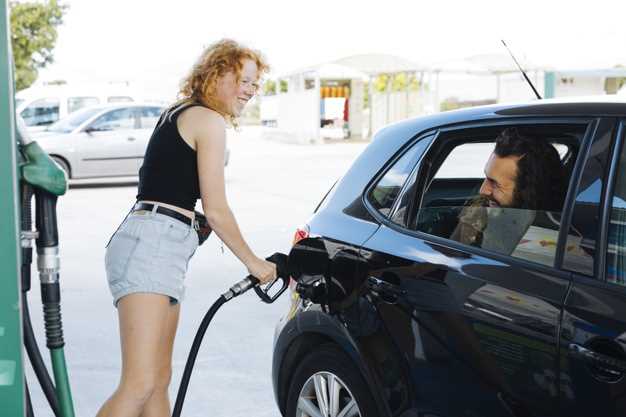 Free Photo | Woman filling up car and smiling to friend at gas station